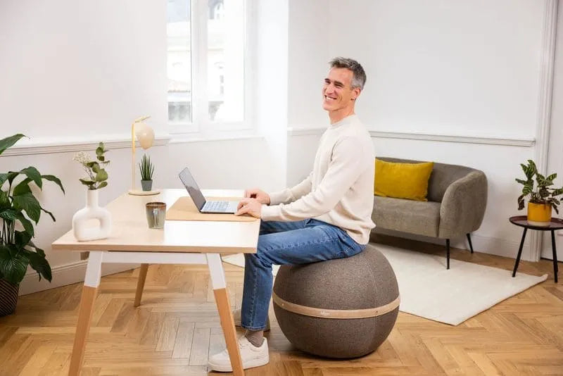 Remplacer sa chaise de bureau par un siège ballon : homme assis à son bureau sur un ballon Bloon